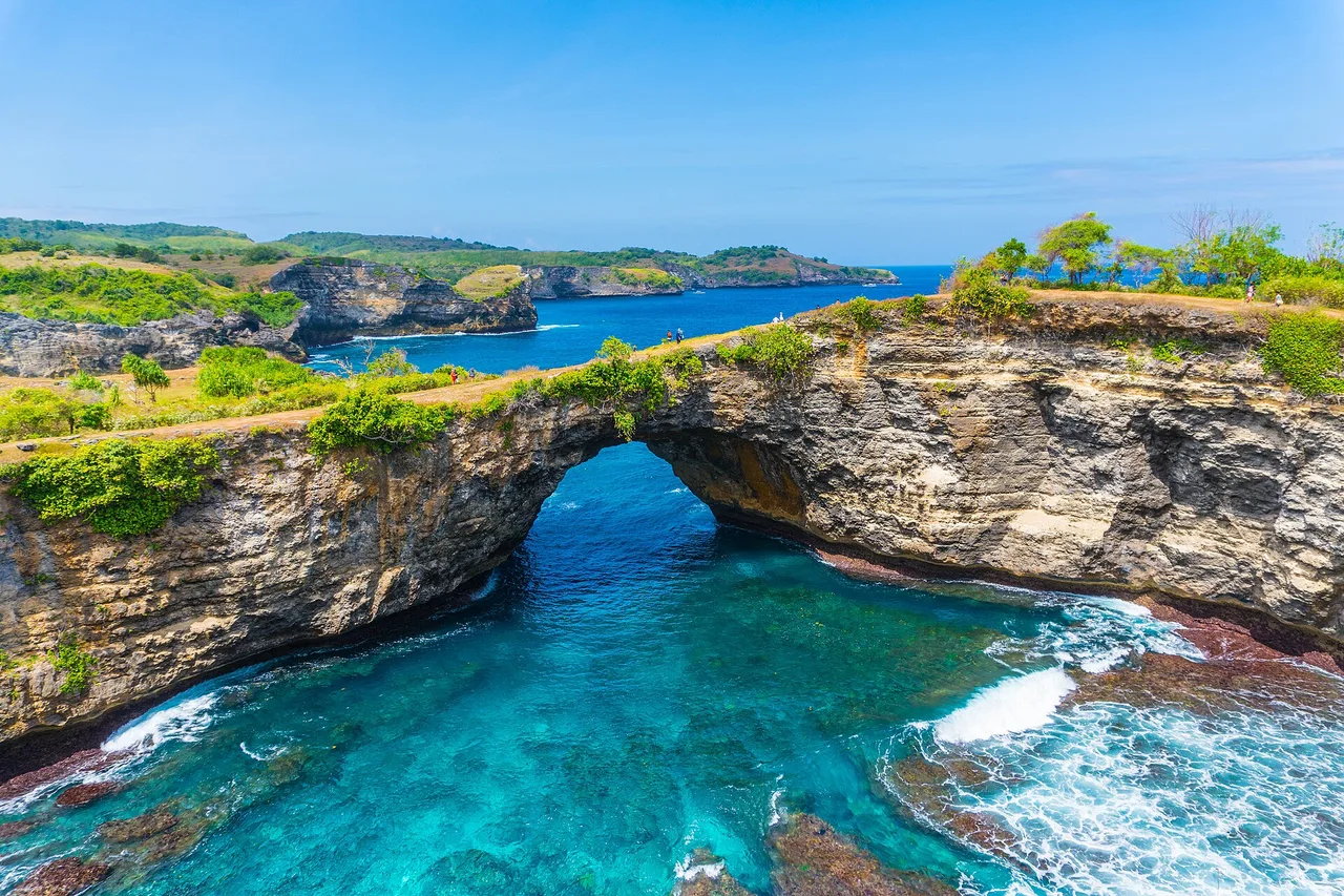 Natürlicher Felsbogen am Broken Beach, Nusa Penida: ein runder Pool aus türkisem Wasser, umgeben von Klippen