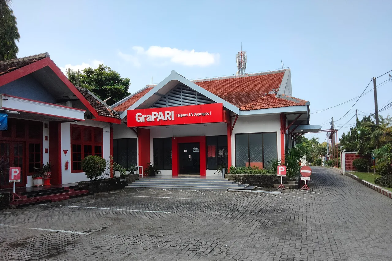 Boutique GraPARI Telkomsel en Indonésie, façade rouge et blanche au bord de la route