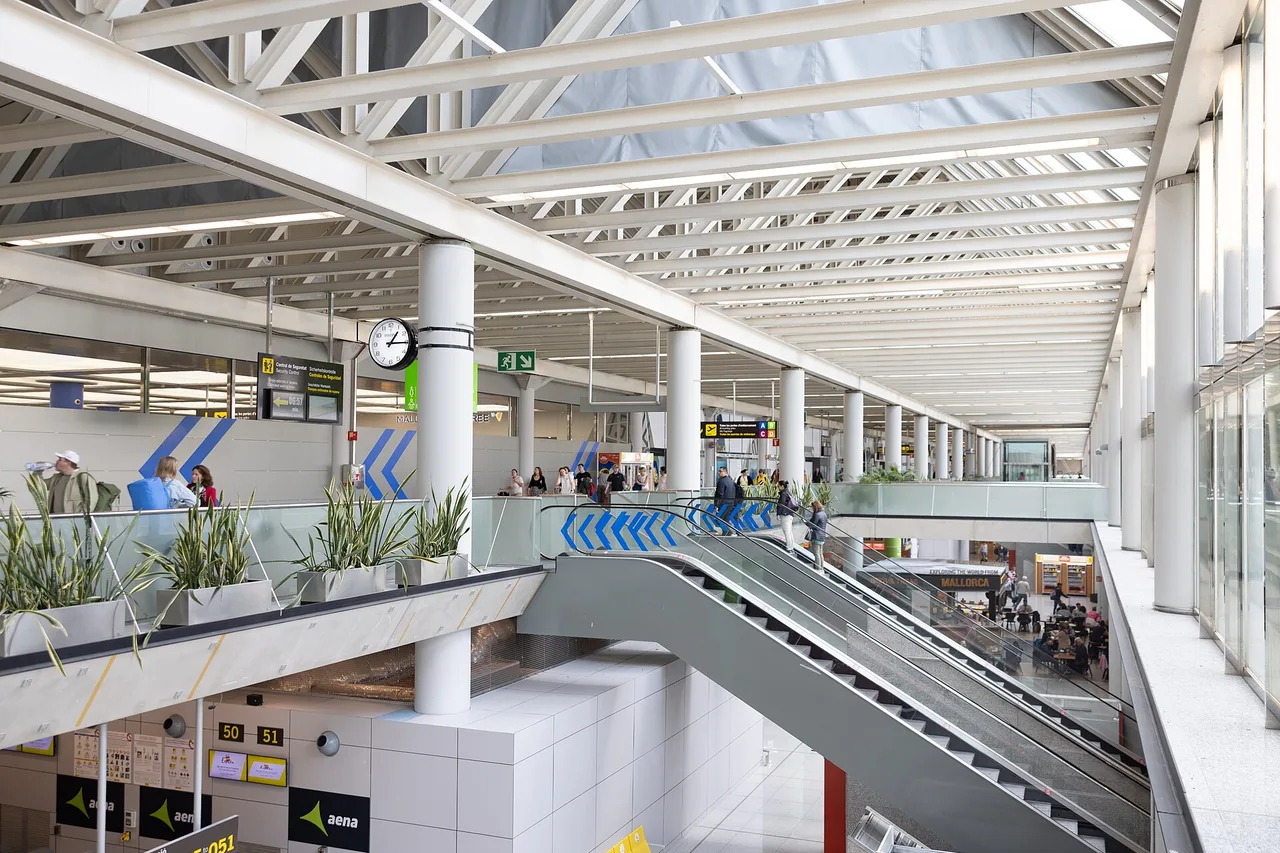 Grand hall lumineux du terminal de l’aéroport de Palma, verrière, escalator, panneaux d’affichage et enseigne Aena
