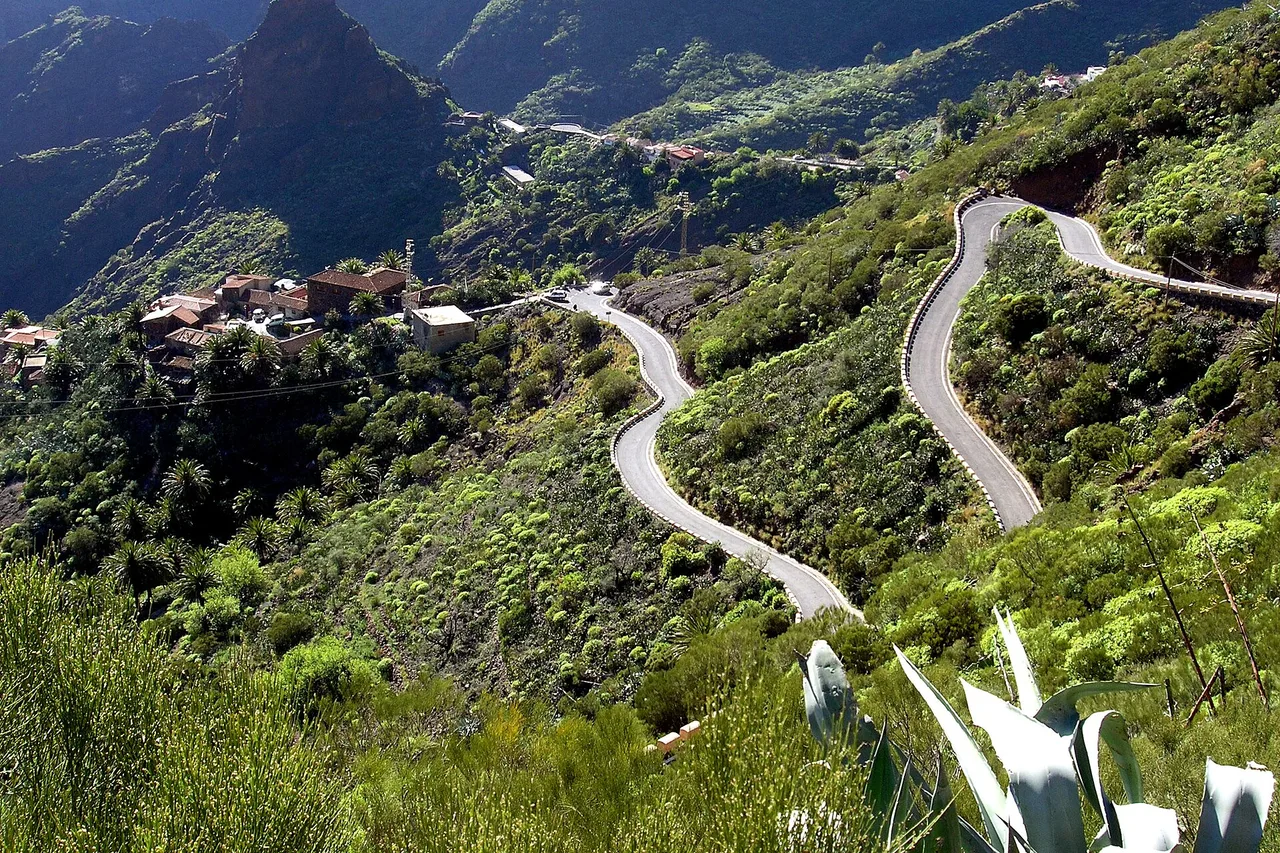 La strada a tornanti per Masca a Tenerife serpeggia sui pendii verdi fino alle case del villaggio di montagna