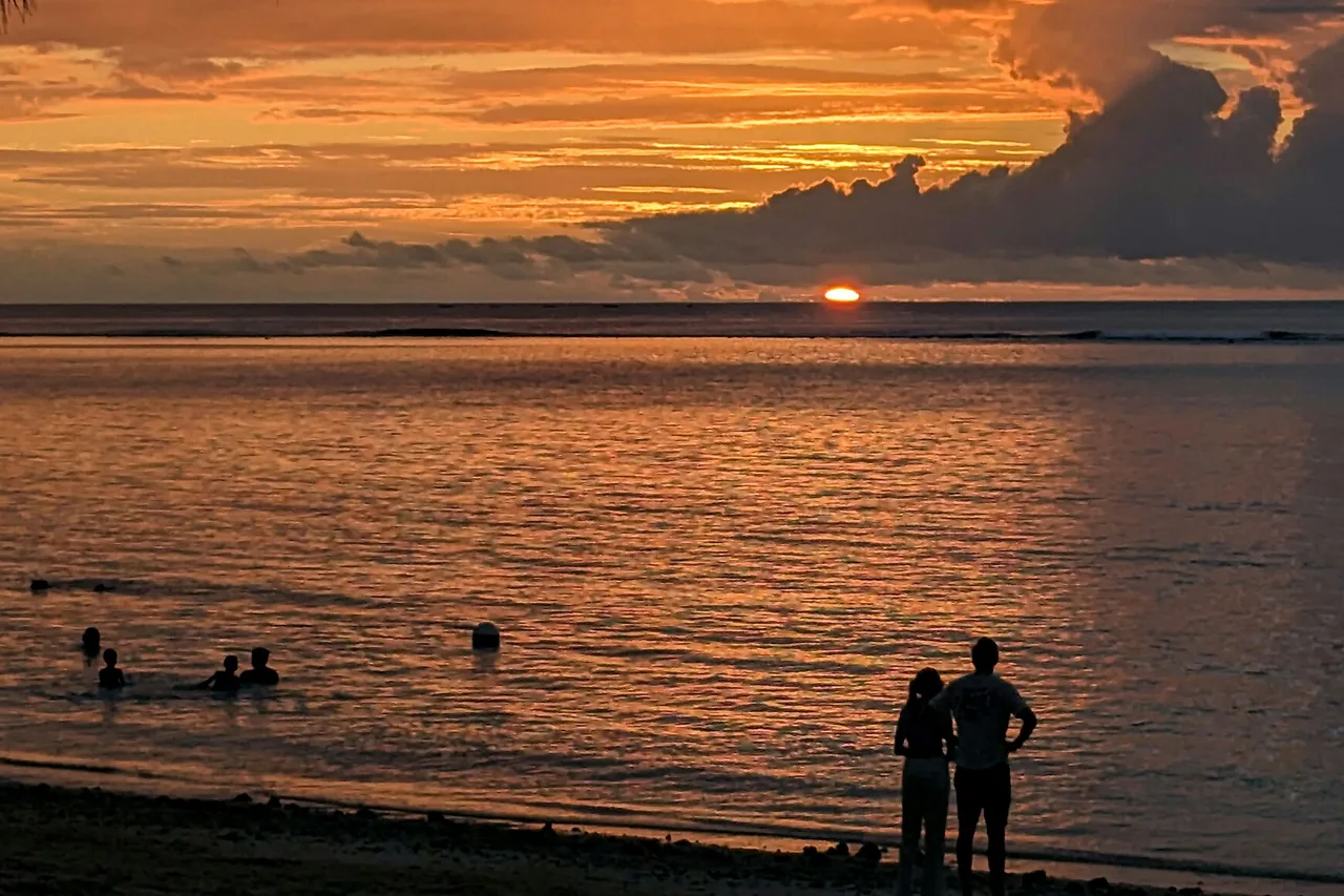 Ein Paar als Silhouette vor dem Sonnenuntergang am Strand von Flic en Flac auf Mauritius
