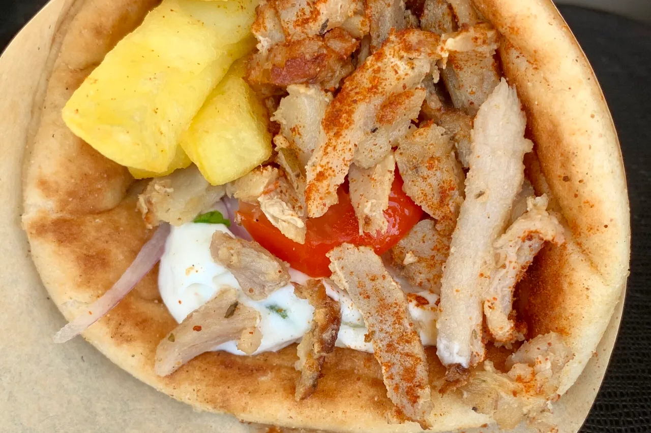 Una pita gyros ad Almyrida, a Creta: focaccia farcita con strisce di carne, patatine, pomodoro, cipolla rossa e tzatziki.