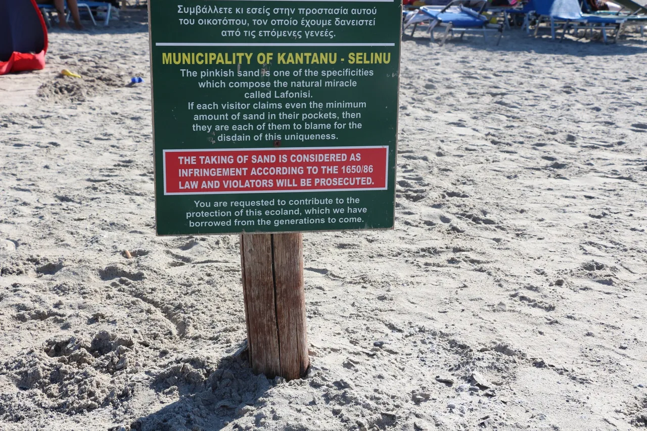Un panneau de la municipalité de Kantanos-Selino planté dans le sable d’Elafonissi, en grec et en anglais : prélever du sable est considéré comme une infraction et sera poursuivi.