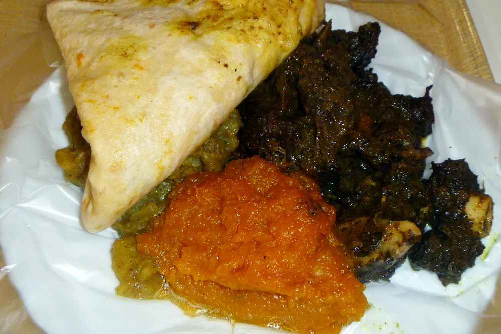 Dholl puri, das bekannteste Streetfood von Mauritius, serviert mit seinen Currys und Rougaille