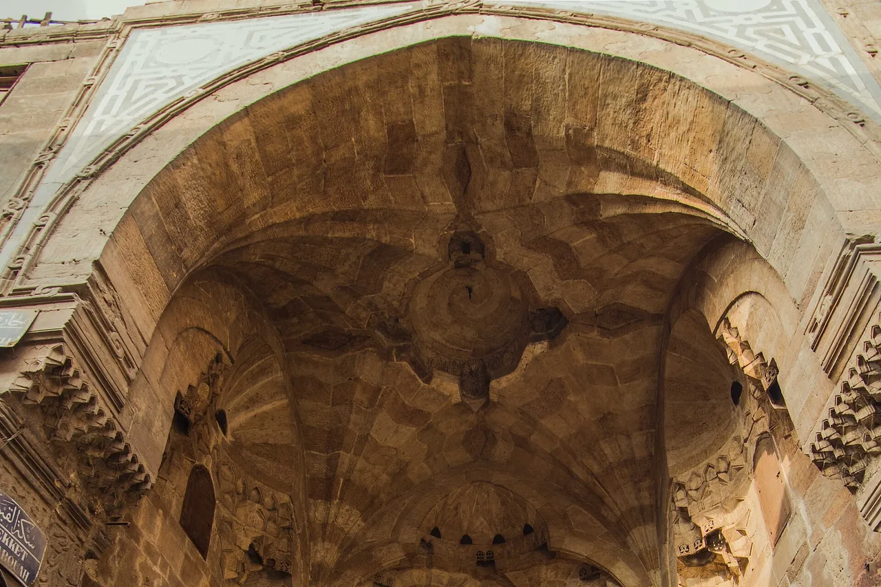 Un portale di pietra decorato, ad arco acuto, nel quartiere del bazar Khan el-Khalili al Cairo.