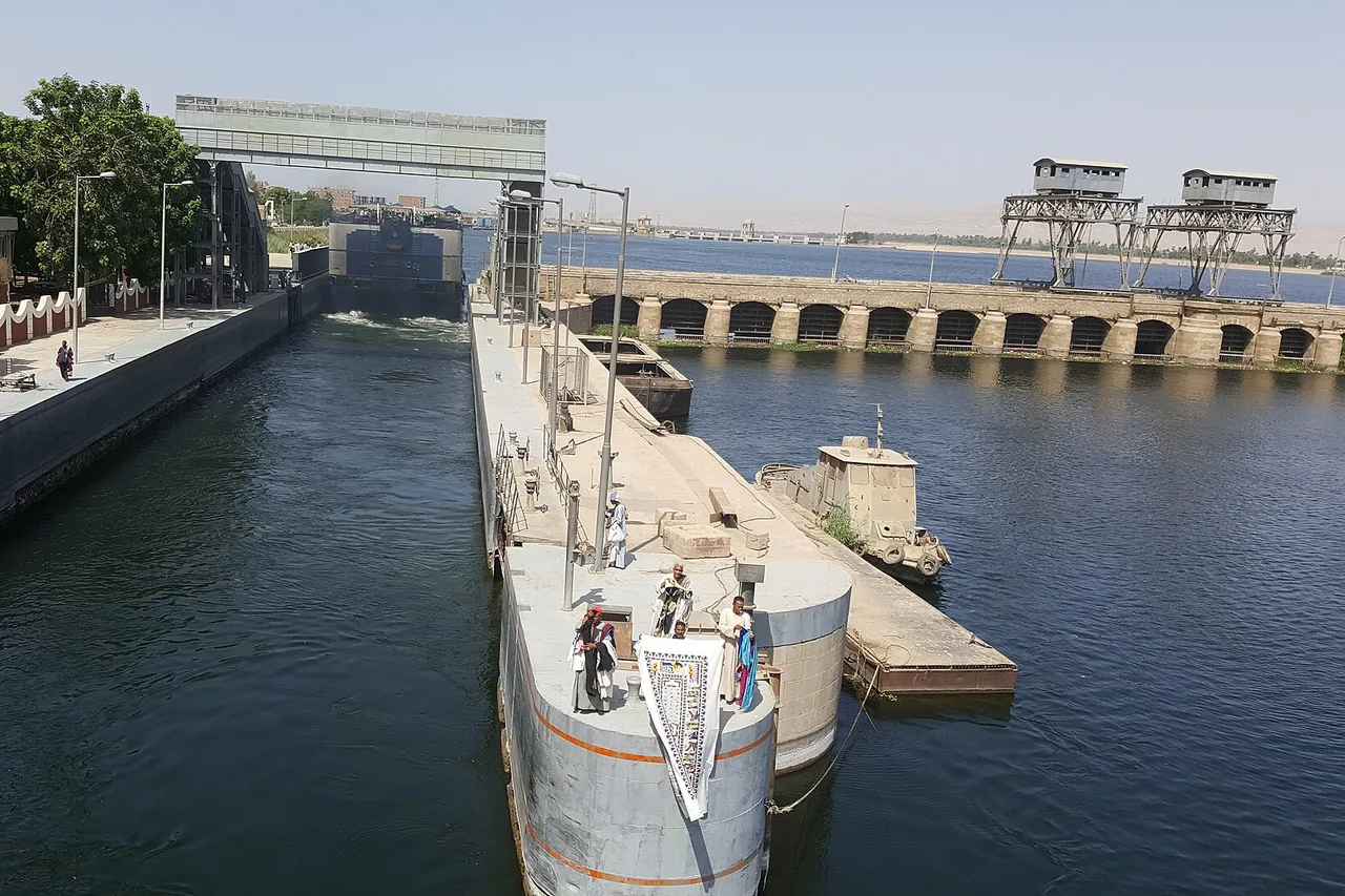 L'écluse d'Esna avec un bateau dans le sas et le barrage en arrière-plan.