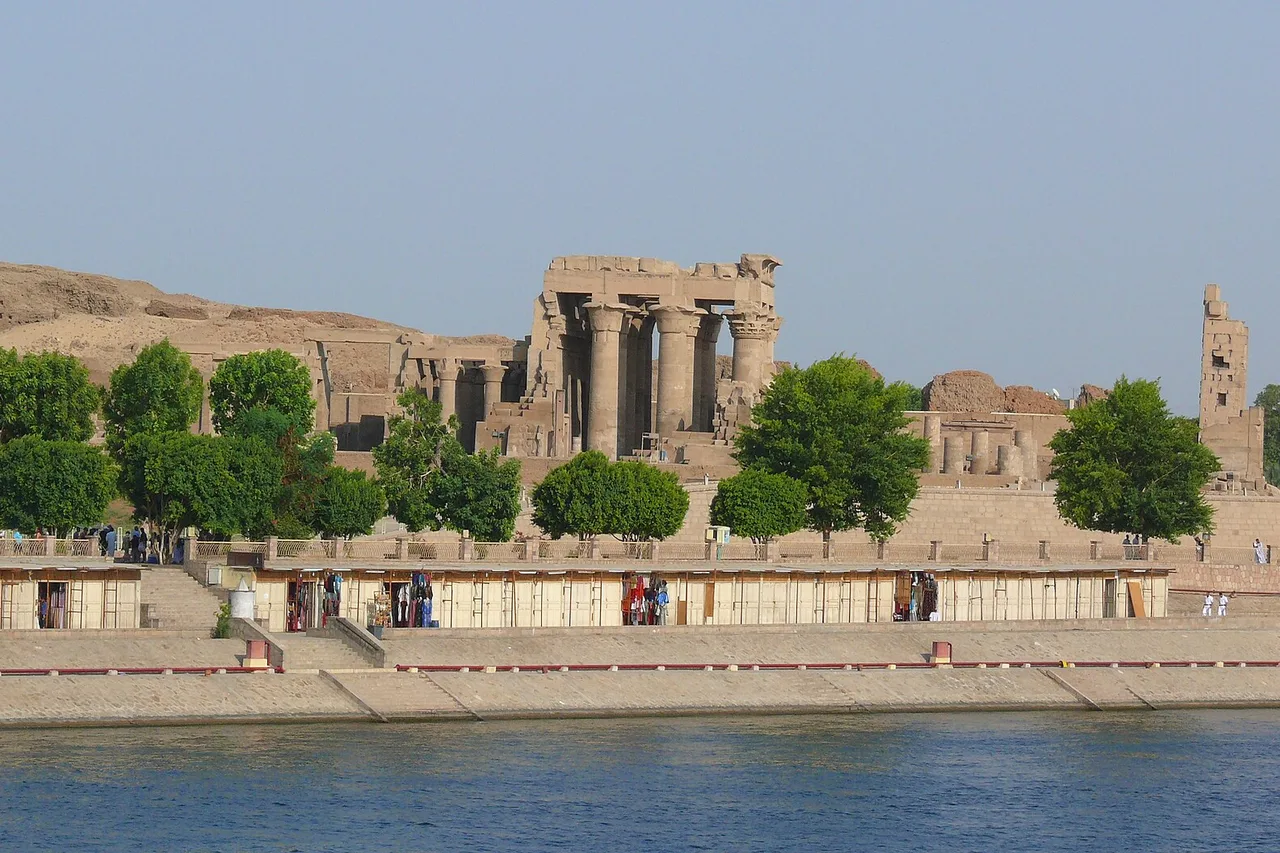 Le temple de Kom Ombo et ses colonnes au bord du Nil, avec une promenade le long de la rive.