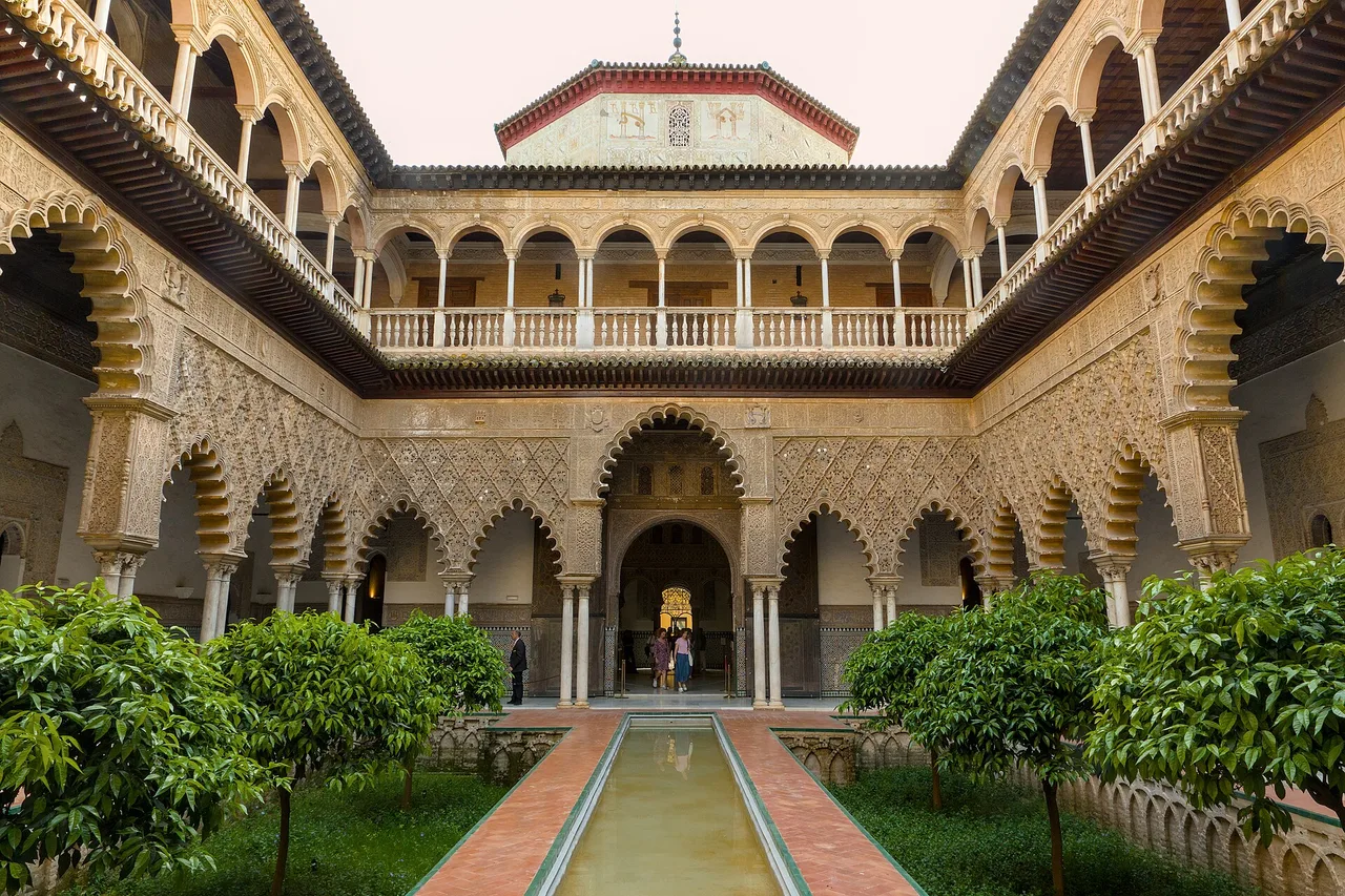 Il Patio de las Doncellas del Real Alcázar di Siviglia, arcate scolpite attorno a una vasca centrale