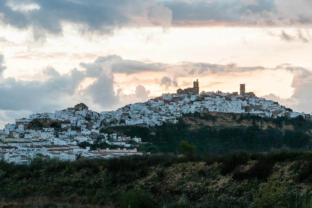 Arcos de la Frontera in der Dämmerung, die weißen Häuser auf dem Felsgrat aufgereiht