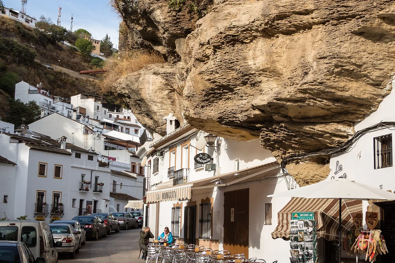 Eine Straße in Setenil de las Bodegas, weiße Häuser unter einem Felsüberhang gebaut