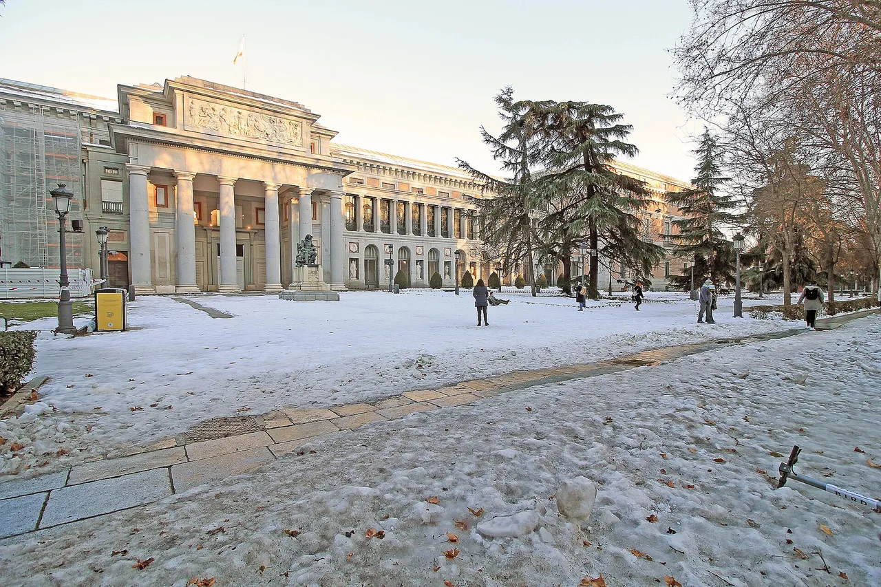 The west façade of the Prado Museum in Madrid under snow, late on a winter afternoon