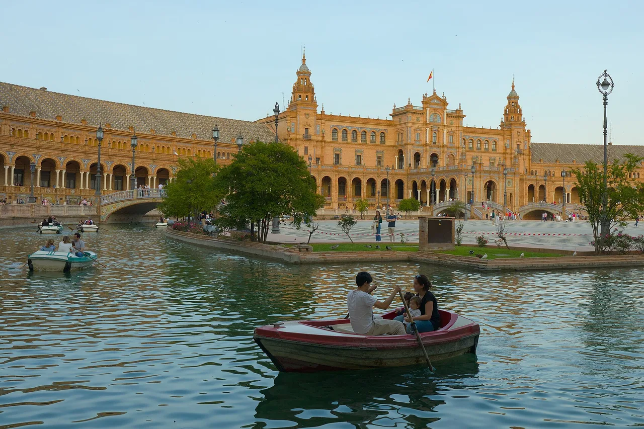 Rowing boats on the canal of the Plaza de España in Seville, in front of the great brick and ceramic palace