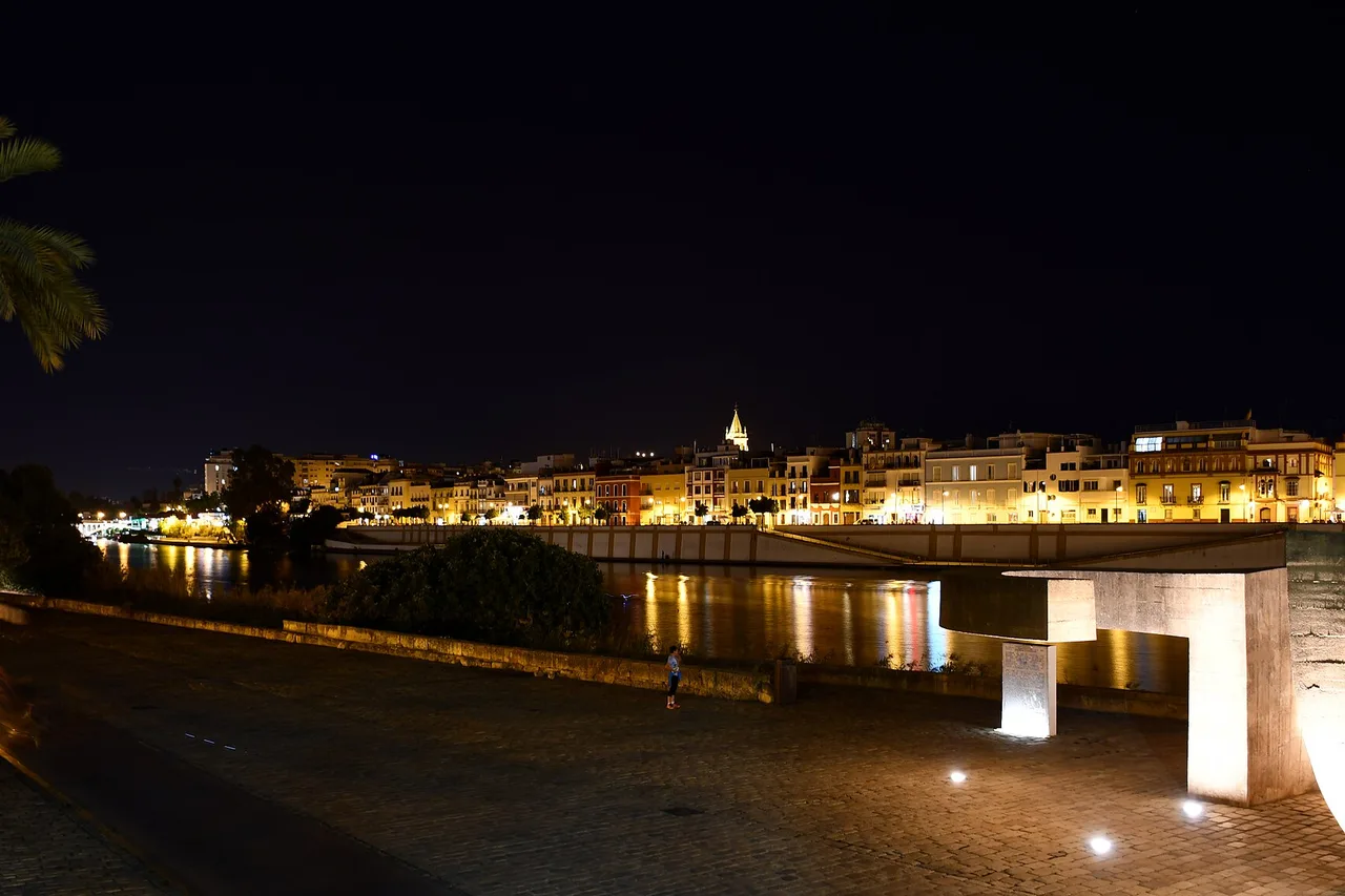 La calle Betis à Triana de nuit, façades colorées reflétées dans le Guadalquivir