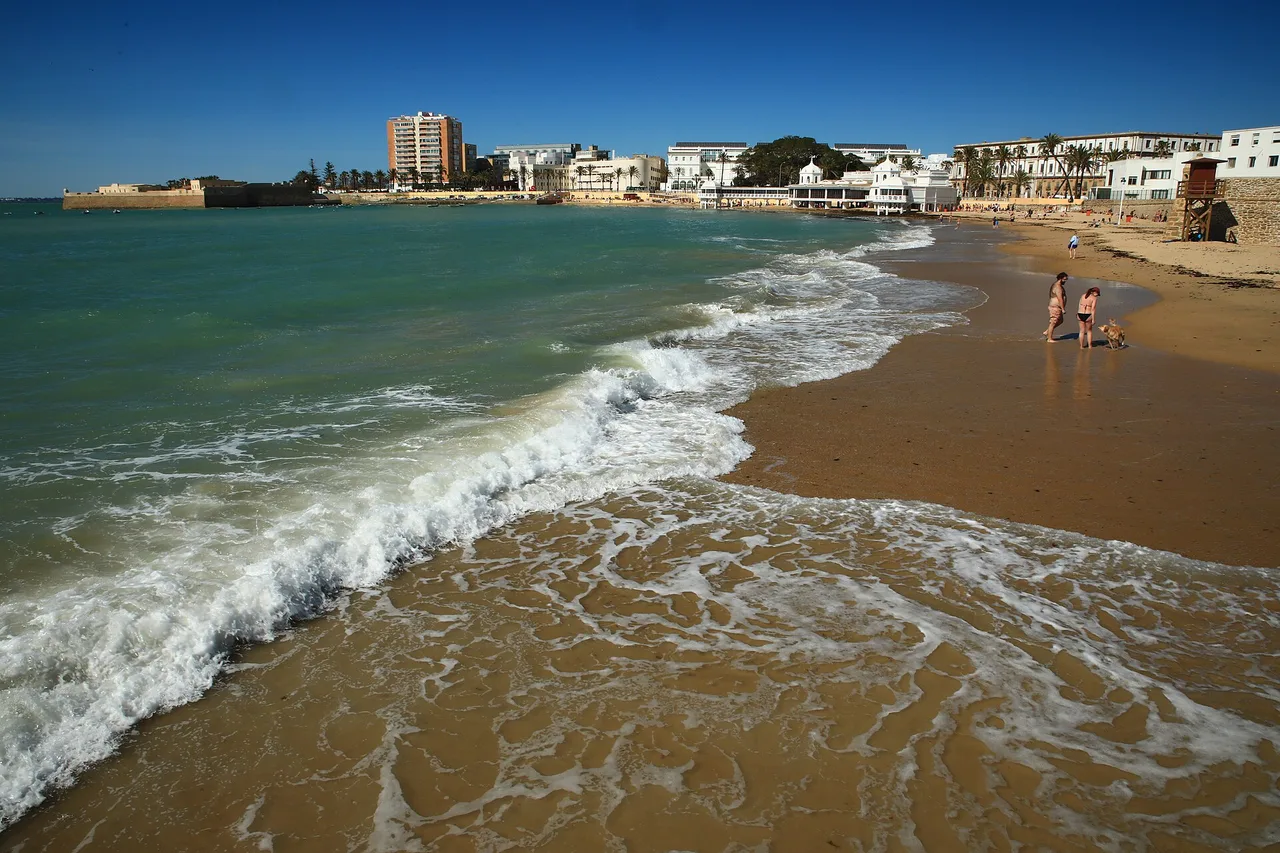 La Caleta beach in Cádiz, Atlantic waves and the city behind