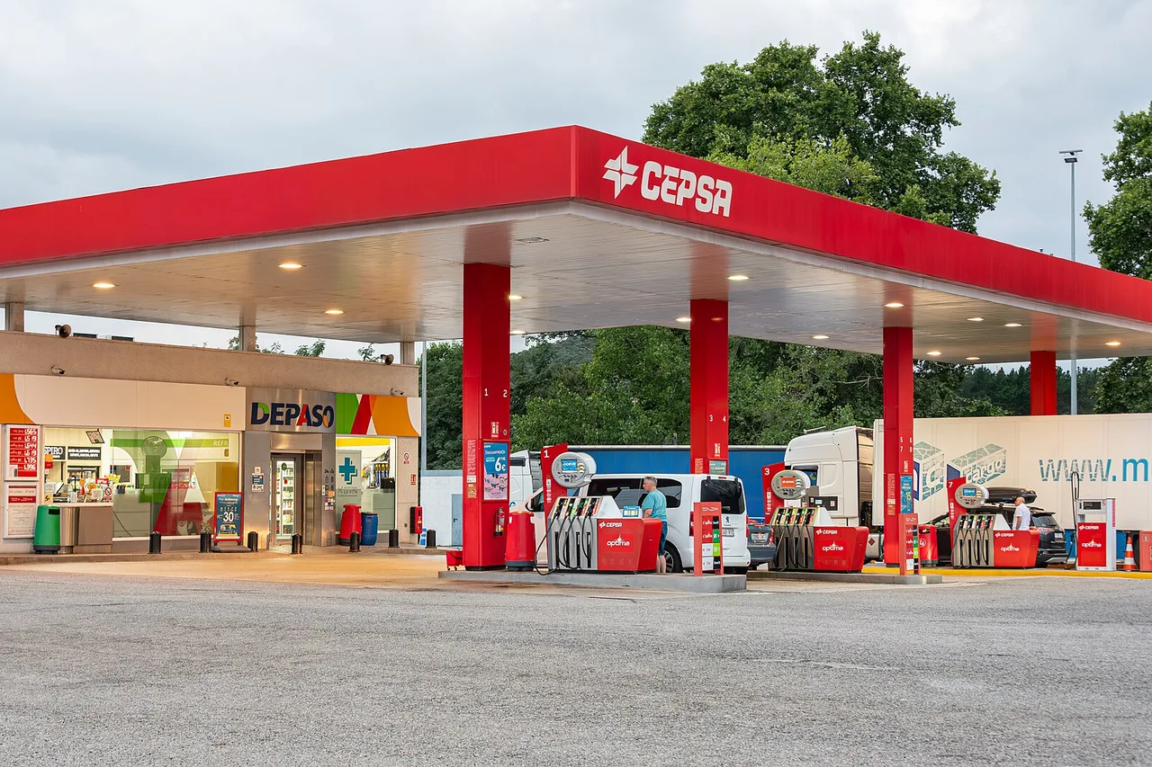 Eine Tankstelle der Marke Cepsa in Spanien mit rotem Dach, Zapfsäulen, einem kleinen Laden und einem Lieferwagen an der Säule