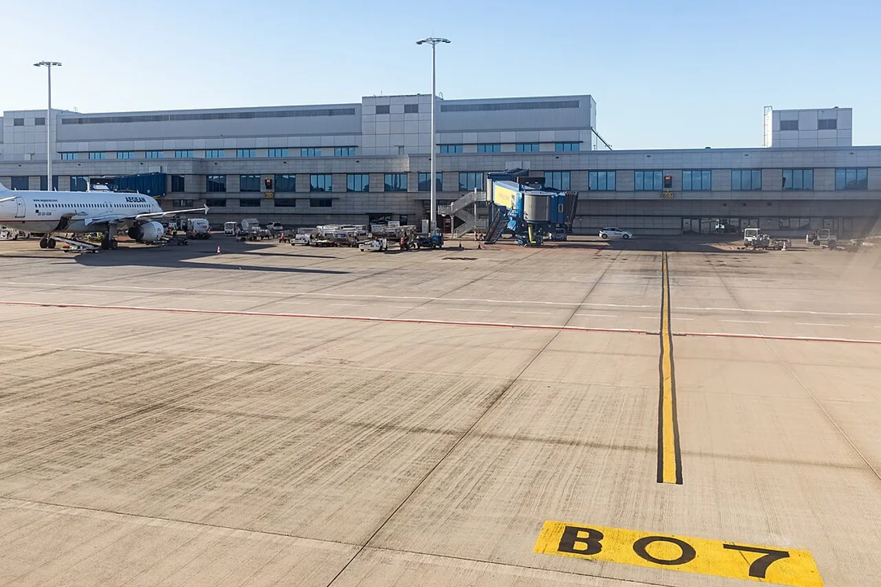 Le tarmac de l’aéroport d’Athènes, un avion à la passerelle et le marquage de poste B07 au sol