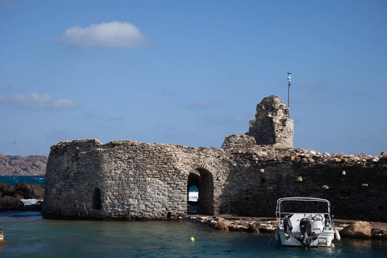 El castillo veneciano de Naoussa en Paros, mar picado y una pequeña barca amarrada