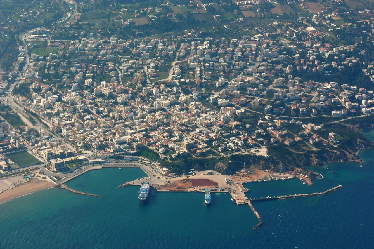Vue aérienne du port de Rafina, une jetée courbe et un ferry accosté au bout