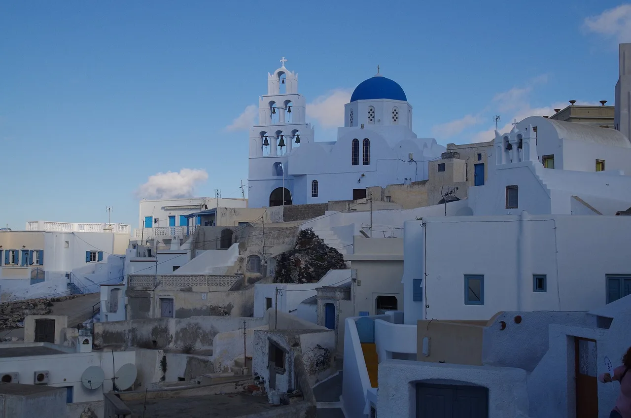 Le village de Pyrgos à l’intérieur des terres, maisons blanches étagées et église à dôme bleu