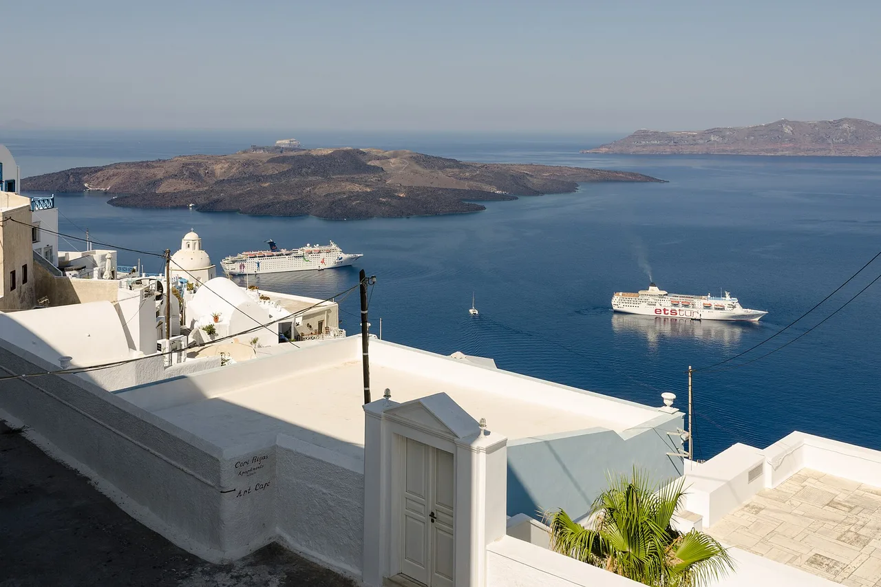 The white rooftops of Fira above the caldera, with two cruise ships anchored below