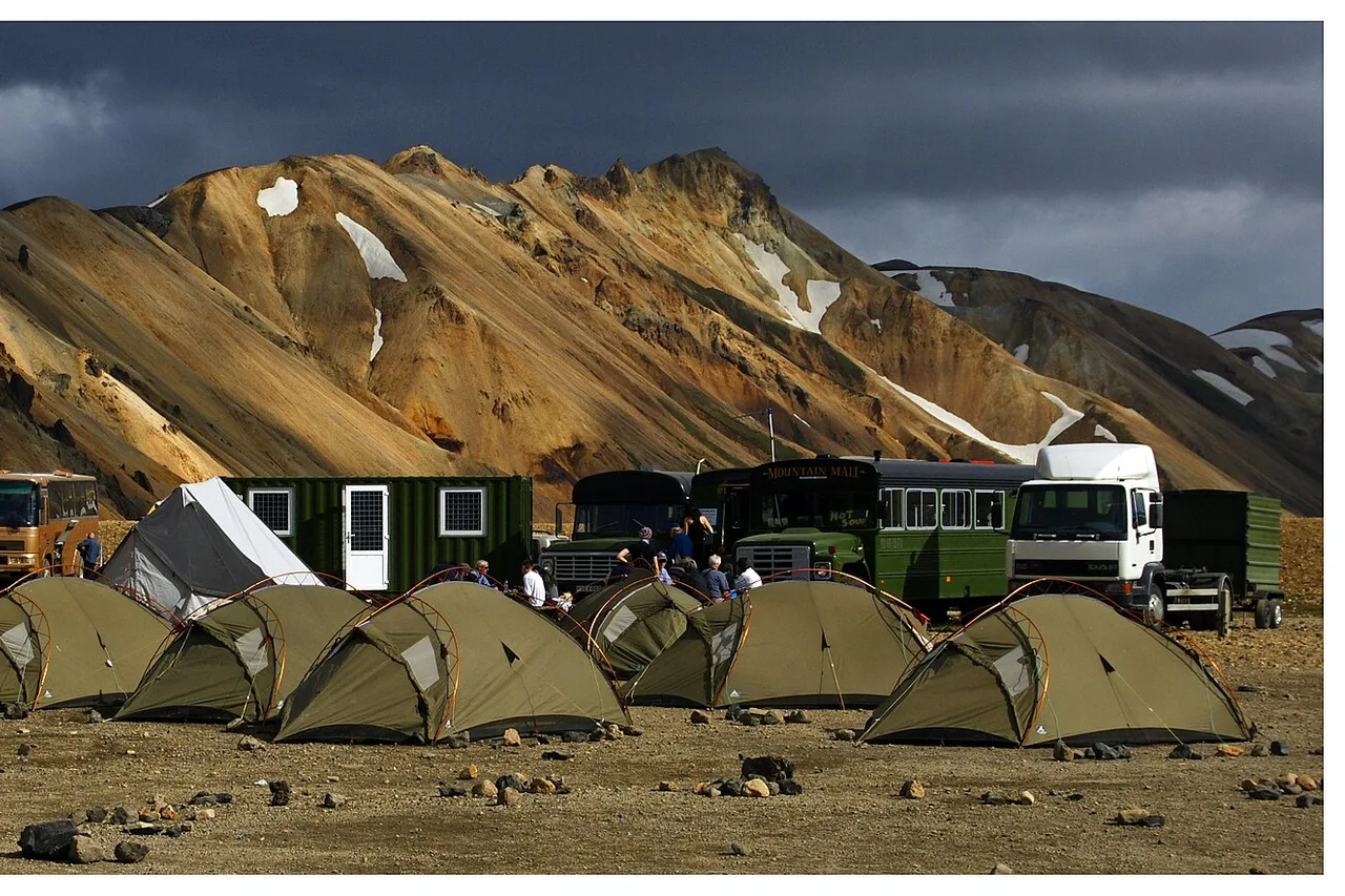 Tents and vehicles on an Icelandic campsite below the mountains