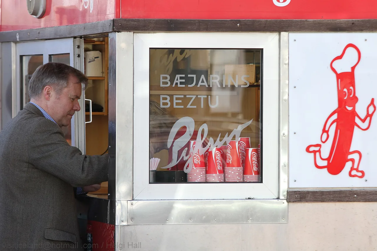 Customer ordering at the window of a hot-dog stand in Reykjavík