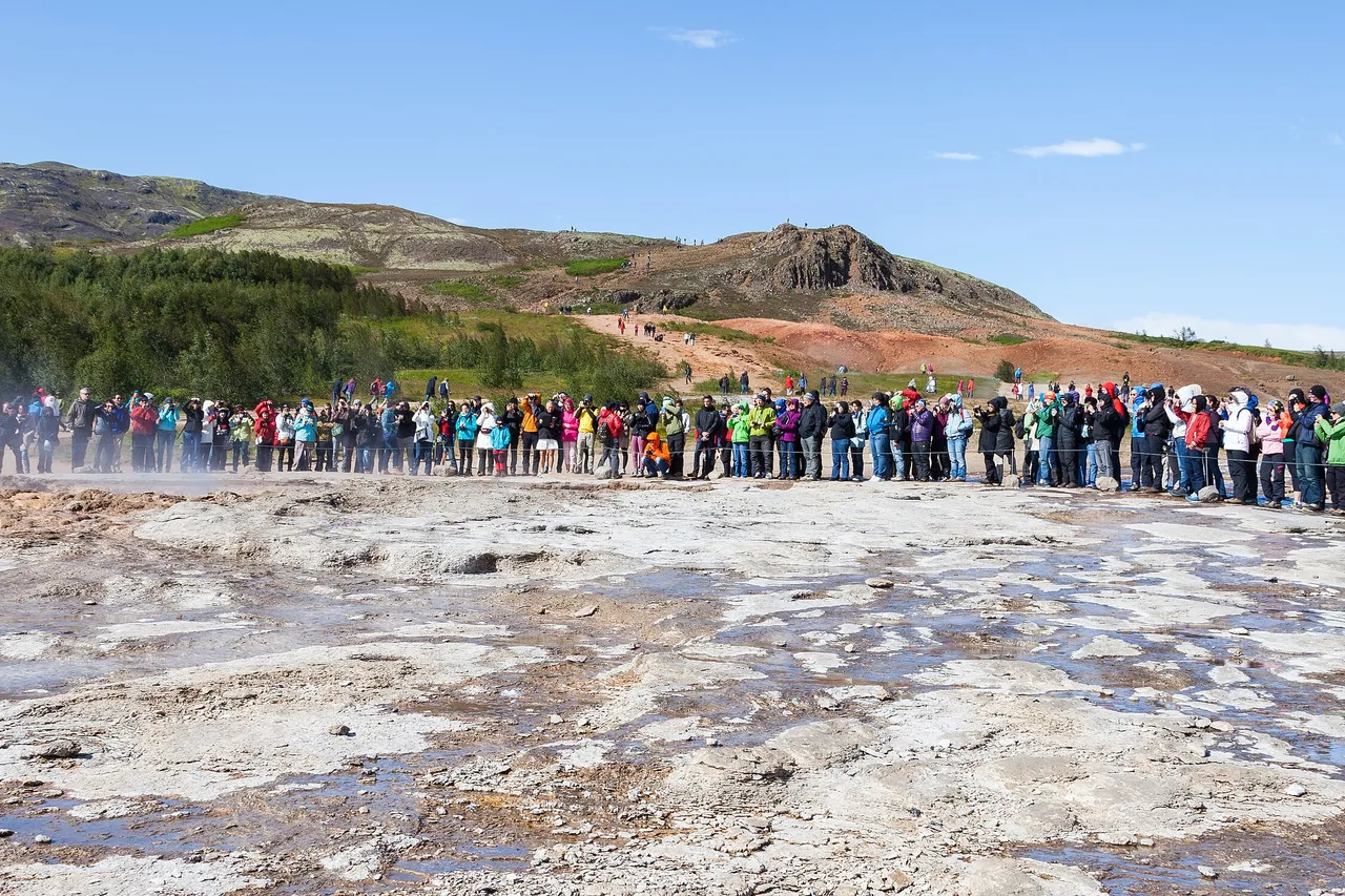 Dichte Menschenmenge im Halbkreis rund um den Geysir Strokkur