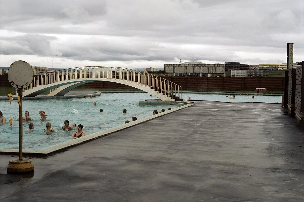 Freibecken des Stadtbads Laugardalslaug unter grauem Himmel, mit Schwimmenden