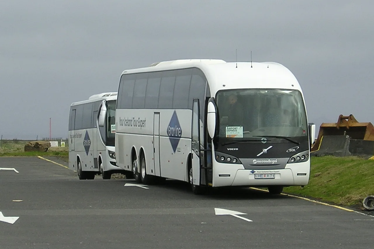 Autocar blanc au logo Gray Line, une pancarte « Airport Express » derrière le pare-brise, garé près de l’aéroport de Keflavík