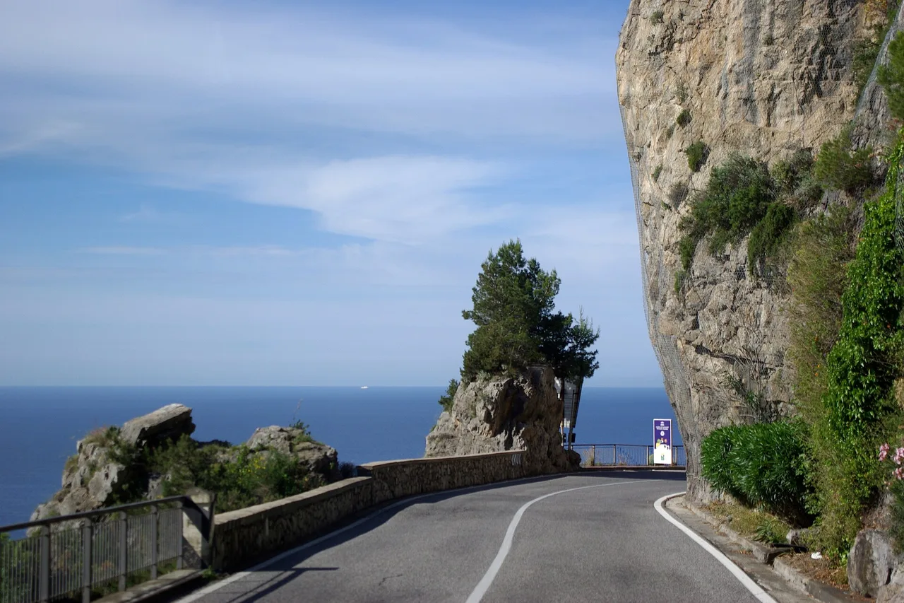 The Strada Statale 163 Amalfitana, a narrow road cut into the cliff above the sea