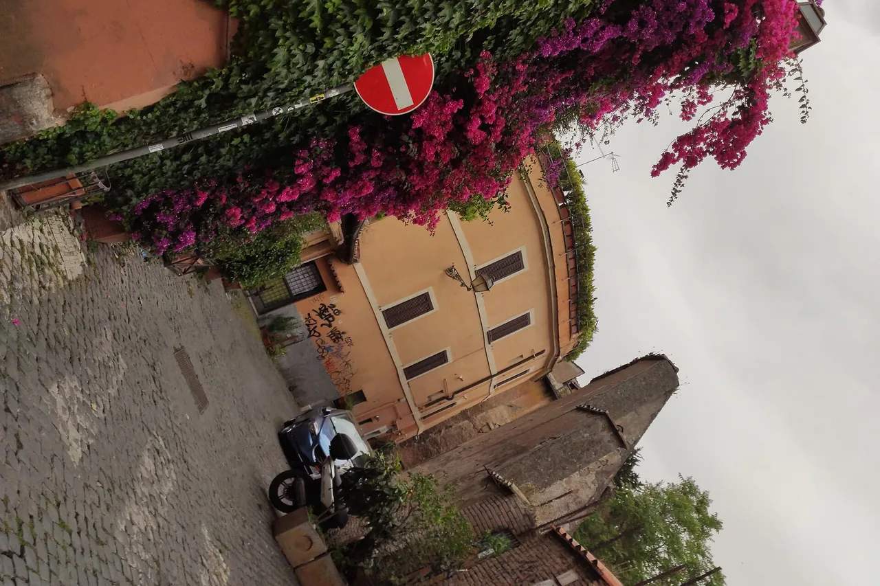 Une ruelle pavée du Trastevere à Rome, façades ocre et linge aux fenêtres
