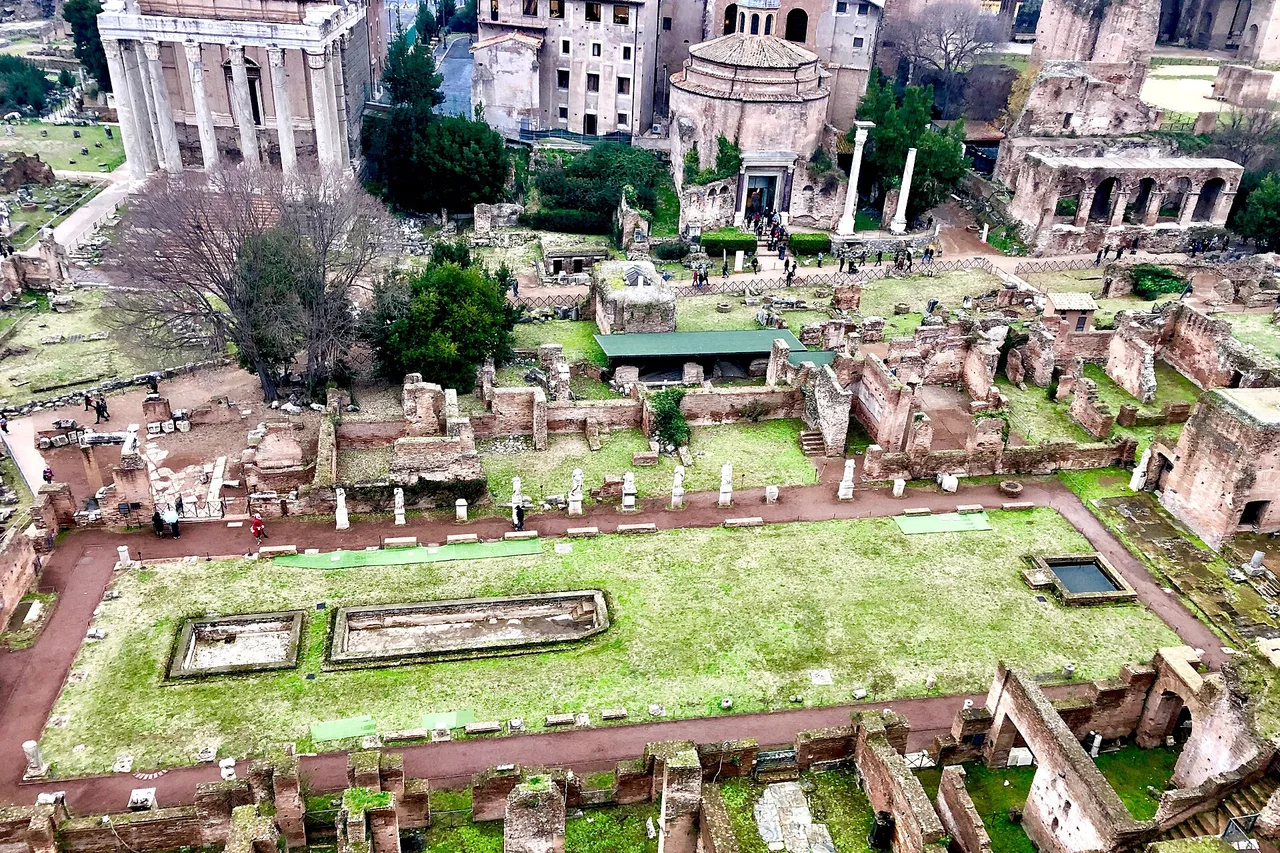 Blick vom Palatin auf die Ruinen im Forum Romanum mit dem Haus der Vestalinnen, einem grünen Innenhof mit zwei Wasserbecken