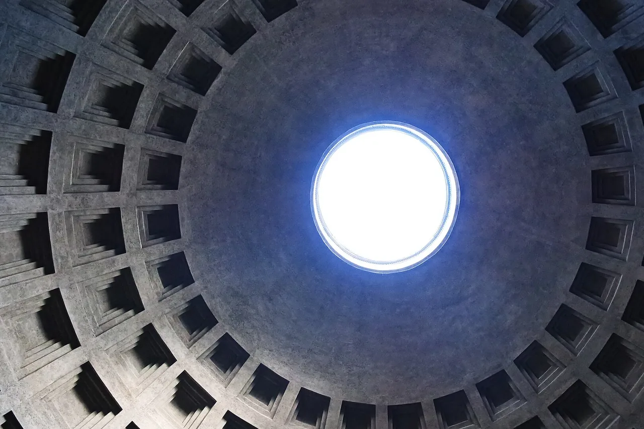 Die Kassettenkuppel des Pantheons in Rom mit der runden Öffnung in der Mitte, durch die helles Licht fällt