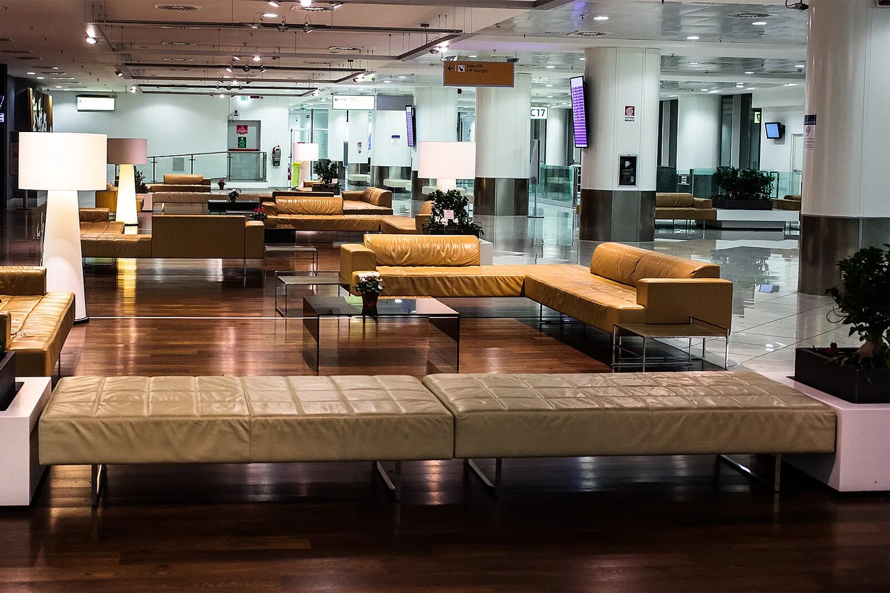 Waiting area with leather sofas and benches in the terminal of Naples-Capodichino airport in the early morning