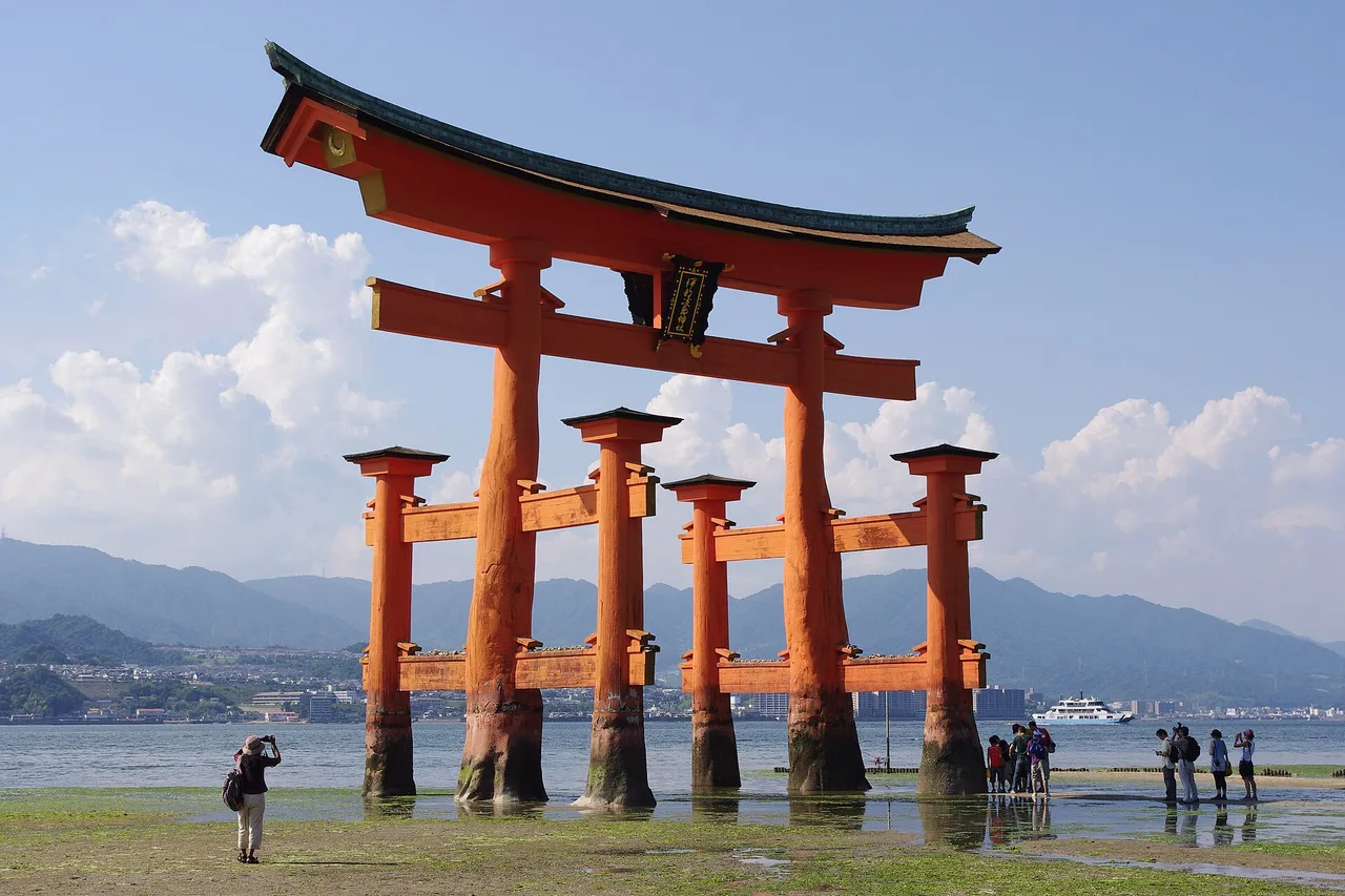 Il grande torii di Itsukushima a Miyajima con la bassa marea, visitatori ai suoi piedi