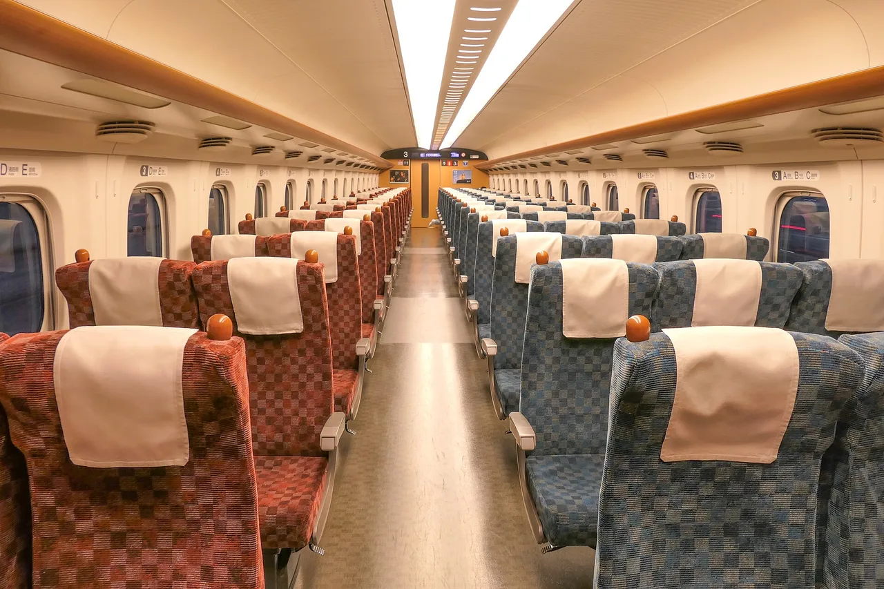 Interno di una carrozza Ordinary dello Shinkansen N700, corridoio centrale e sedili