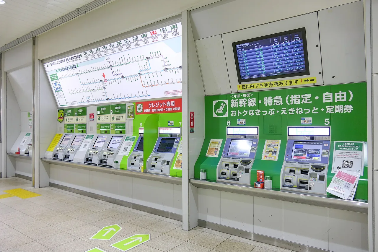 A bank of JR East ticket machines beneath the fare map of a station