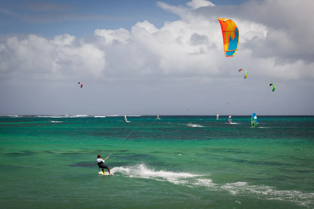 Kitesurfer und Windsurfer in der türkisen Lagune von Le Morne, einem bekannten Kitespot auf Mauritius