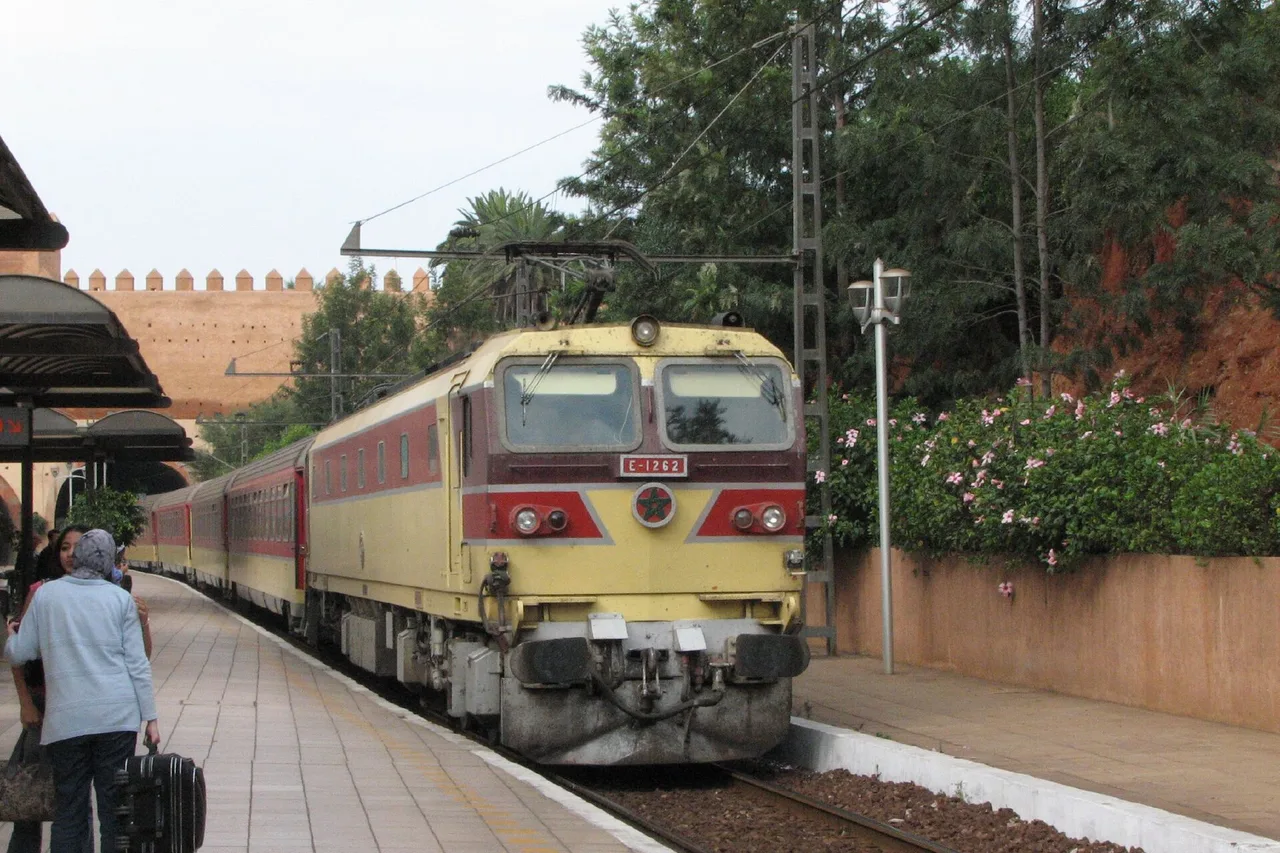 Un train de l’ONCF à quai en gare de Rabat-Ville, un voyageur avec son sac sur le quai