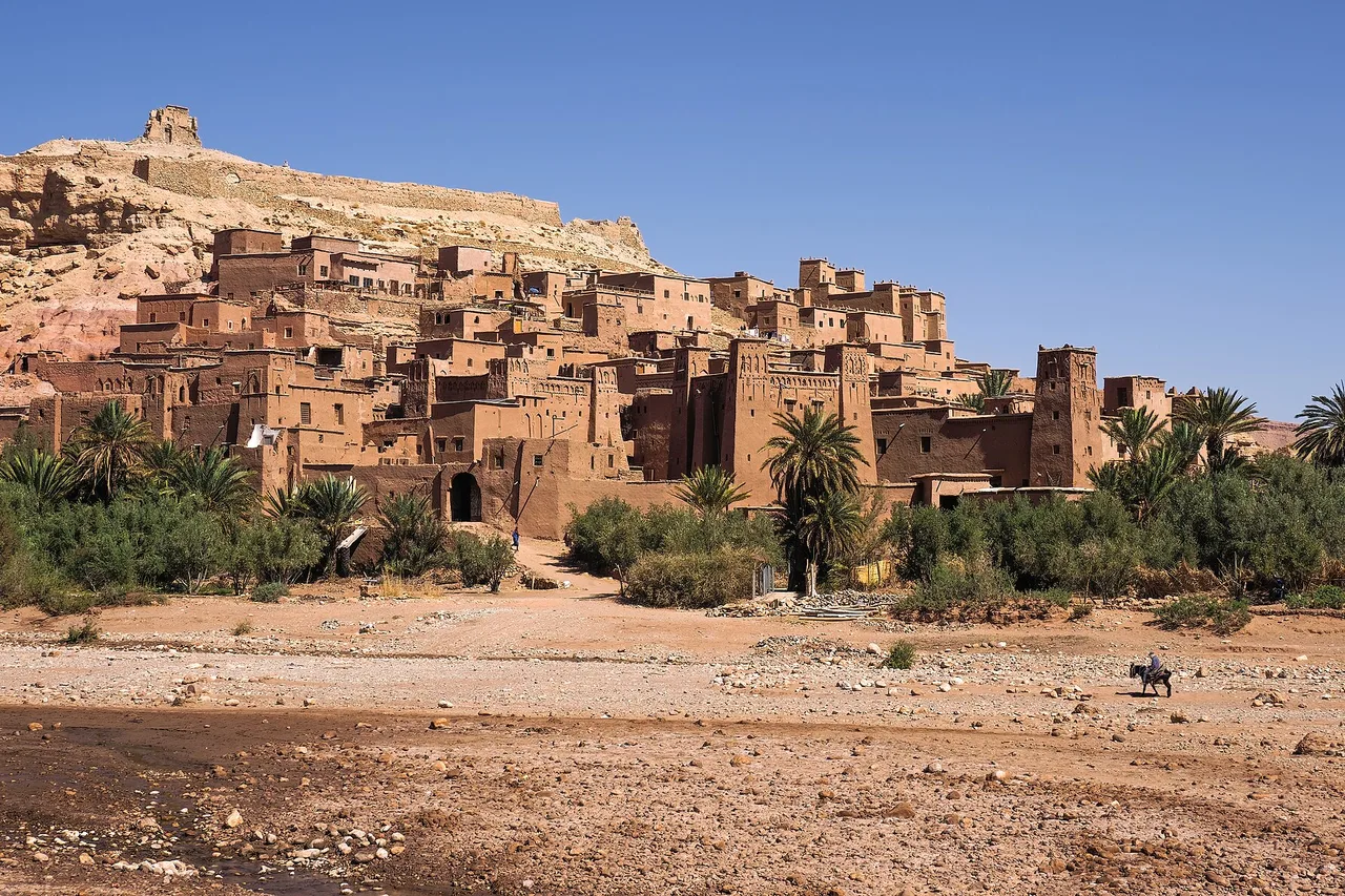 The ksar of Aït Ben Haddou, its earthen houses stacked up the hillside facing the palm grove