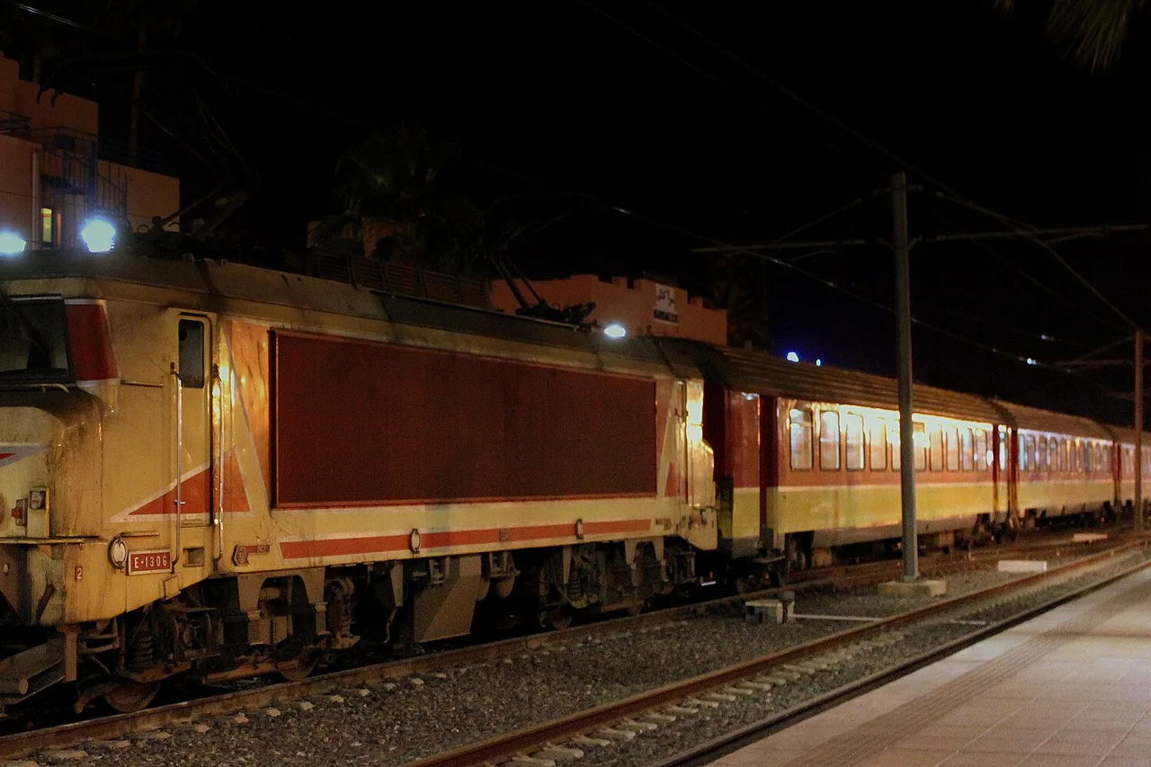 An ONCF locomotive at the platform in Marrakech station, under palm trees