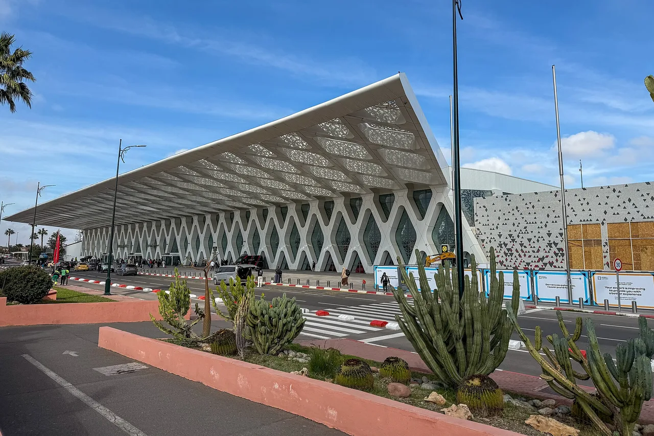 La terminal 1 del aeropuerto de Marrakech-Menara, con su techo blanco calado en rombos, cactus y una palmera en primer plano