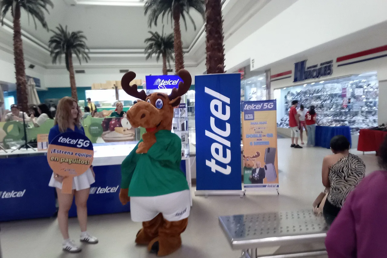 Telcel-Werbestand in einem Einkaufszentrum in Mexiko mit Maskottchen, Hostess und blauen Aufstellern
