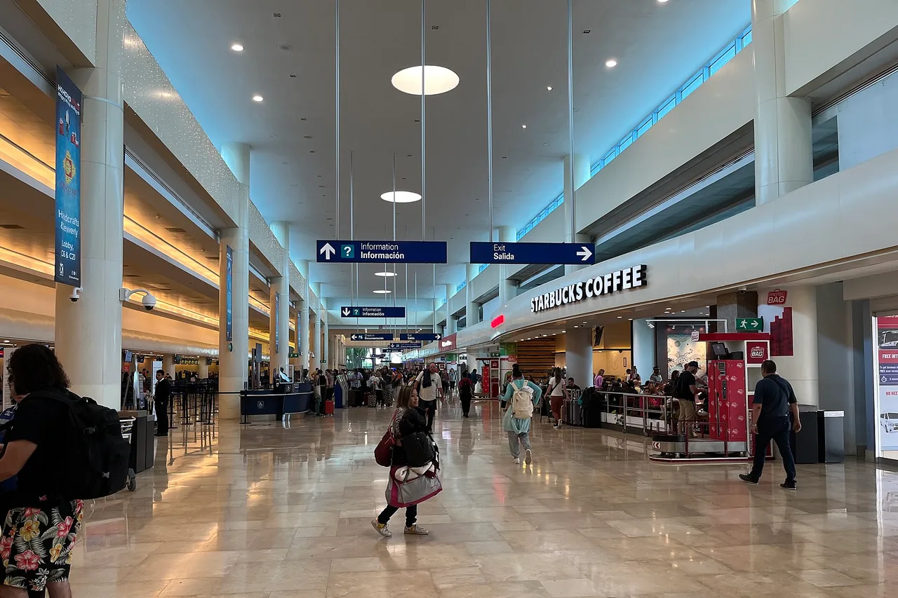 La sala arrivi dell'aeroporto internazionale di Cancún, viaggiatori che camminano con i bagagli