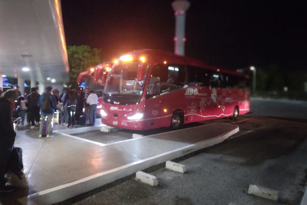 La banchina degli autobus al terminal 2 dell'aeroporto di Cancún, un pullman fermo di notte