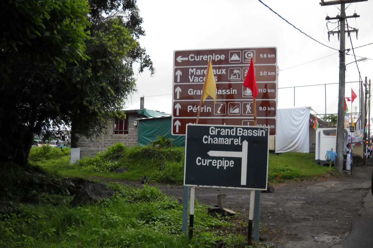 Zwei Wegweiser am Rand einer Straße auf Mauritius, mit den Richtungen Curepipe, Grand Bassin und Chamarel