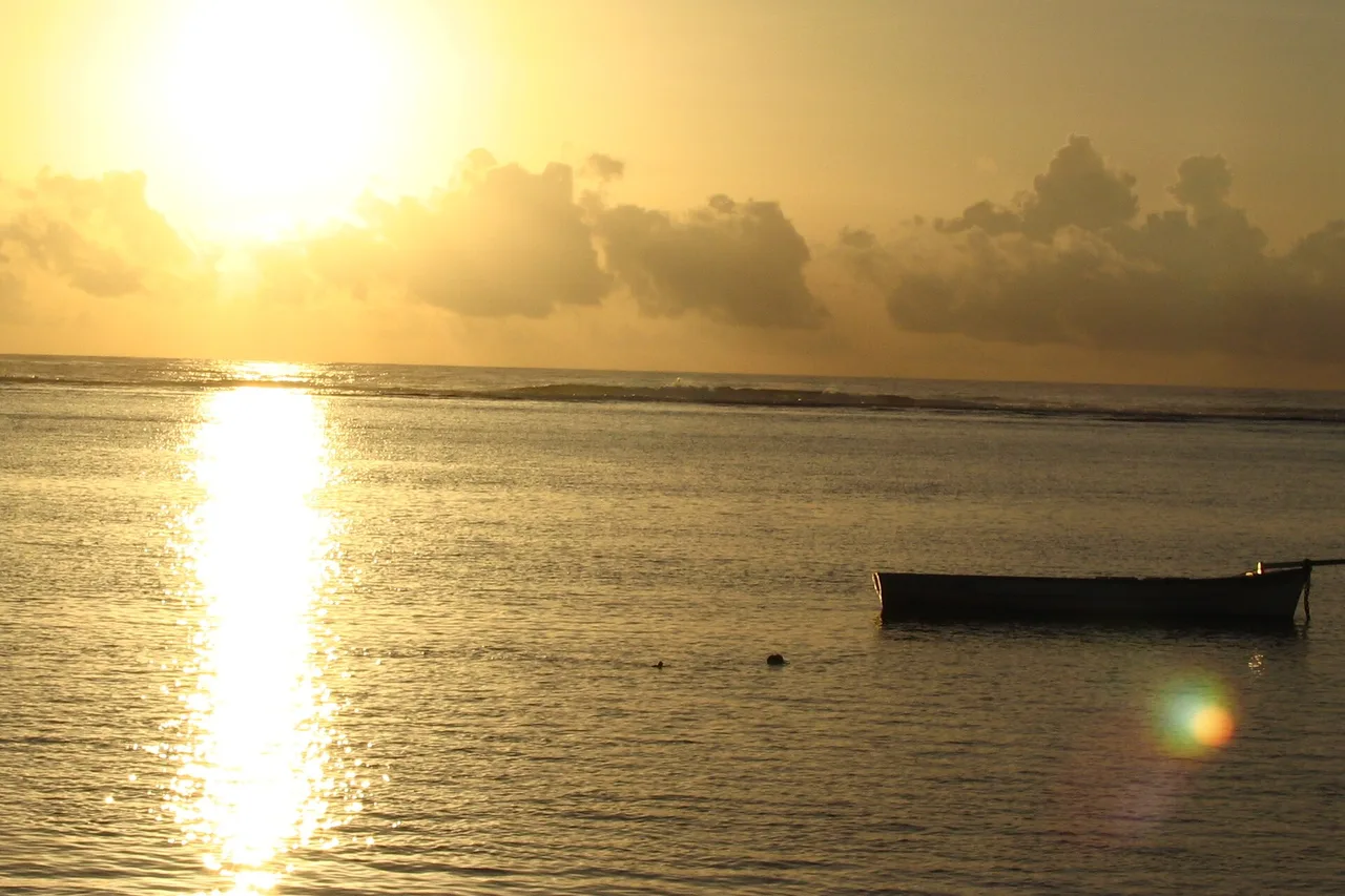 Fischerboot auf einer goldenen Lagune bei Sonnenuntergang, Mauritius