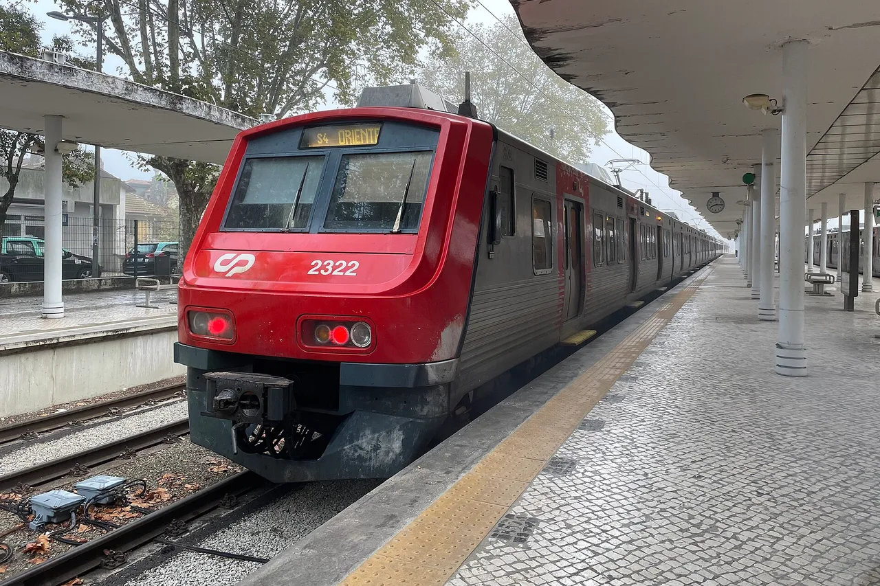 A red CP suburban train at the platform of Sintra station, with a covered platform on columns on the right