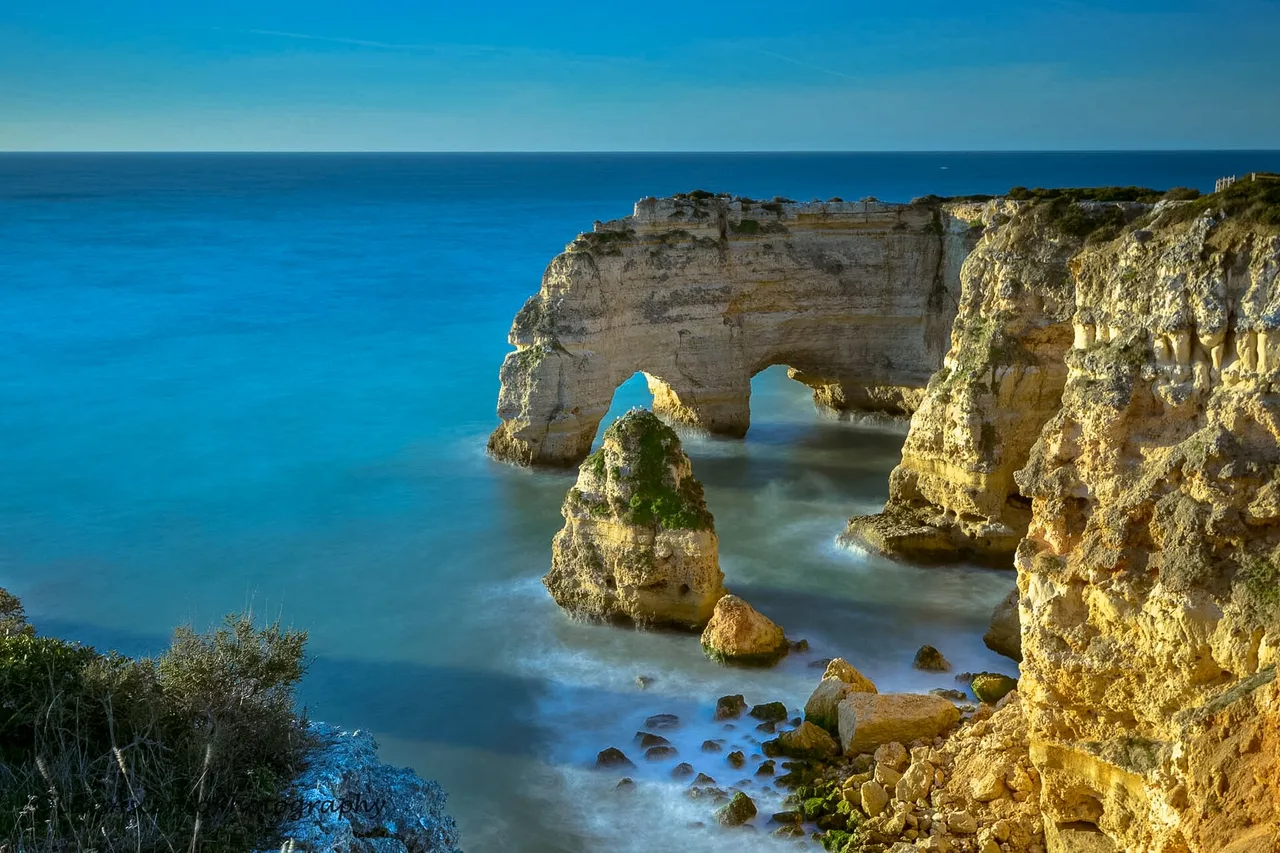 Der doppelte Felsbogen der Praia da Marinha von der Klippe aus, über türkisfarbenem Wasser