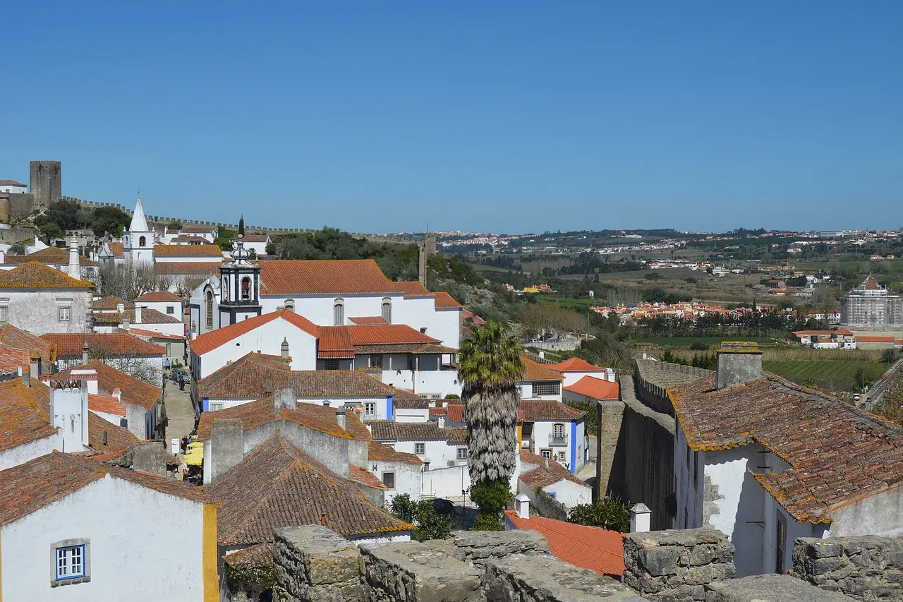 The walkway along the ramparts of Óbidos looking down over the tiled roofs of the walled village
